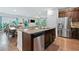 Open kitchen view with granite counters, stainless appliances, dark cabinets, and an island with barstool seating at 3255 Morgan Rd, Buford, GA 30519