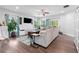 Bright living room featuring a large sectional sofa, ceiling fan, and hardwood floors at 3255 Morgan Rd, Buford, GA 30519