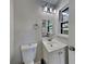 Well-lit half bathroom featuring a white vanity, modern light fixture, and a toilet at 3284 Salem Se Ln, Conyers, GA 30013