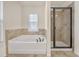 Modern bathroom featuring a soaking tub and separate glass-enclosed shower at 5711 Keys Way, Lithonia, GA 30058