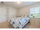 Bedroom featuring a comfortable bed with bright blue comforter, neutral walls, and natural light at 5711 Keys Way, Lithonia, GA 30058