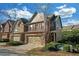 Side view of townhome showcasing brick and siding, complemented by manicured landscaping at 5711 Keys Way, Lithonia, GA 30058
