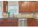 Kitchen with dark wood cabinets, granite countertops, and stainless steel dishwasher at 5711 Keys Way, Lithonia, GA 30058