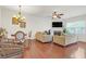 Living room with hardwood floors, a fireplace, and a dining area; neutral color palette at 5711 Keys Way, Lithonia, GA 30058