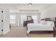 Large primary bedroom featuring tray ceiling, carpet floors, and ample natural light at 5711 Keys Way, Lithonia, GA 30058