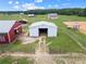Aerial view showcases multiple barns and sheds on a well-maintained grassy farm property at 654 Euharlee Five Forks Rd, Kingston, GA 30145
