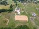 Expansive aerial view of a farm showcasing a main residence, barns, sheds, and a horse riding arena at 654 Euharlee Five Forks Rd, Kingston, GA 30145