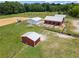 Aerial view showcases multiple barns and sheds on a well-maintained grassy farm property at 654 Euharlee Five Forks Rd, Kingston, GA 30145