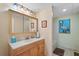 Bathroom featuring a wooden vanity, sink, mirror, light fixture, and a blue pelican painting at 654 Euharlee Five Forks Rd, Kingston, GA 30145