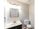 Half bath including a black cabinet, sink, toilet, tile floors, and neutral walls at 1416 Emerald Pine Ct, Lawrenceville, GA 30043