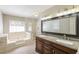 Luxurious primary bath featuring a double vanity, soaking tub, separate shower, and elegant lighting at 1416 Emerald Pine Ct, Lawrenceville, GA 30043
