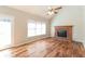Bright living room featuring a brick fireplace, hardwood floors, and a ceiling fan at 1416 Emerald Pine Ct, Lawrenceville, GA 30043