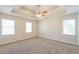 Large main bedroom with a tray ceiling, carpet floors, and lots of natural light at 1416 Emerald Pine Ct, Lawrenceville, GA 30043