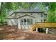 Exterior view of the home showing the deck, sunroom, back door, and wooded backyard at 175 River Run, Roswell, GA 30075