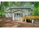 View of the house from the backyard, featuring a deck with stairs and screened-in sunroom at 175 River Run, Roswell, GA 30075
