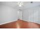A spacious bedroom featuring wood floors, a ceiling fan, and a double door closet for ample storage at 175 River Run, Roswell, GA 30075