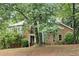 Two-story home with brick and stucco facade, accented by mature trees and landscaping at 175 River Run, Roswell, GA 30075
