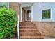 Charming front porch with brick steps, stucco siding, and decorative columns, leading to the main entrance at 175 River Run, Roswell, GA 30075