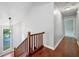 Hallway with hardwood flooring and staircase with wooden railing at 175 River Run, Roswell, GA 30075