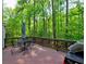 Relaxing deck area, featuring a BBQ grill, table and chairs with view of surrounding trees at 351 Ridgewater Dr, Marietta, GA 30068