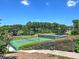 View of tennis courts surrounded by lush greenery from atop the hill, accessible via stone steps at 351 Ridgewater Dr, Marietta, GA 30068