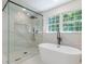 This is a bathroom with a glass shower, soaking tub, and large windows at 418 Mockingbird, Smyrna, GA 30082