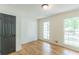 Bright bedroom featuring hardwood floors, two large windows, and a gray interior door at 418 Mockingbird, Smyrna, GA 30082