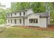 Striking two-story home showcasing a blend of white brick and siding, complemented by dark trim and a manicured lawn at 418 Mockingbird, Smyrna, GA 30082