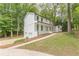 Two-story white brick house with a convenient side-entry two-car garage, set amidst a lush, tree-filled landscape at 418 Mockingbird, Smyrna, GA 30082