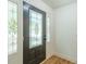Close-up of a decorative front door with glass panels, framed by white trim and a partial view of hardwood flooring at 418 Mockingbird, Smyrna, GA 30082