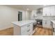 Updated kitchen showcasing a white island, stainless steel appliances, and gray backsplash at 418 Mockingbird, Smyrna, GA 30082