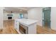 Kitchen island featuring a microwave, quartz countertops and view to a living space with a fireplace at 418 Mockingbird, Smyrna, GA 30082