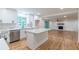 Open kitchen featuring white cabinets, stainless appliances, and view into living room with fireplace at 418 Mockingbird, Smyrna, GA 30082