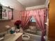 Pink-themed bathroom with a shower-tub combo and accessibility features, plus vintage fixtures at 8118 Sw Collier Sw St, Covington, GA 30014