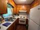 Compact kitchen with classic wood cabinetry and appliances, offering a functional cooking space at 8118 Sw Collier Sw St, Covington, GA 30014