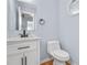 Stylish powder room featuring a sleek vanity with marble countertop, modern fixtures, and a framed mirror at 8914 Gardener Dr, Jonesboro, GA 30238