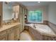 Bathroom featuring a soaking tub with tile surround and a large patterned glass window for privacy at 1043 Elizabeth Ne Ct, Atlanta, GA 30306