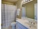 Standard bathroom featuring a single sink vanity, toilet, and shower with striped curtain at 1043 Elizabeth Ne Ct, Atlanta, GA 30306
