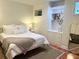 Bedroom with white bed, terracota floor, small window, and shelf unit at 1043 Elizabeth Ne Ct, Atlanta, GA 30306