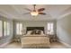 Bedroom featuring a plush bed, tray ceiling, and bright windows with shutter blinds at 1043 Elizabeth Ne Ct, Atlanta, GA 30306