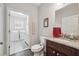 Cozy bathroom features granite counters, dark wood cabinetry, and adjacent laundry room at 2485 Millwater Xing, Dacula, GA 30019