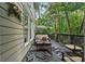 Inviting outdoor deck with comfortable seating, umbrella, and views of the surrounding lush greenery at 2485 Millwater Xing, Dacula, GA 30019
