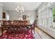 Formal dining room with a bright chandelier, detailed trim, large windows, and classic wood furniture at 2485 Millwater Xing, Dacula, GA 30019