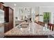 Kitchen island with granite countertops and stainless sink overlooking a living room with large windows at 2485 Millwater Xing, Dacula, GA 30019