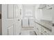 Bright laundry room featuring white cabinets, granite countertops and modern appliances at 2485 Millwater Xing, Dacula, GA 30019
