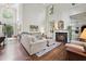 Open-concept living room boasting a fireplace, built-in bookshelves, hardwood floors, and large windows at 2485 Millwater Xing, Dacula, GA 30019