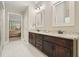 Dual sinks are conveniently located near the doorway in this bright, tiled bathroom at 3267 Standing Peachtree Nw Trl, Kennesaw, GA 30152