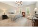 This carpeted bedroom features neutral walls, a ceiling fan, and two windows for natural light at 3267 Standing Peachtree Nw Trl, Kennesaw, GA 30152