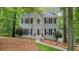 Charming gray two-story home featuring black shutters, a landscaped yard, and mature trees at 3267 Standing Peachtree Nw Trl, Kennesaw, GA 30152