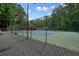 Community tennis court surrounded by fencing and trees for recreational play at 3267 Standing Peachtree Nw Trl, Kennesaw, GA 30152
